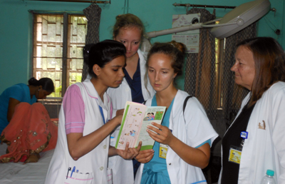 A Salokaya student shows a health brochure to members of the U-M group