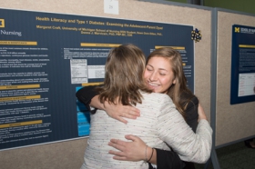 Margaret Kraft hugs Dr. Marvicsin to celebrate their winning poster
