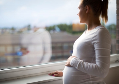 Image of pregnant woman looking out window