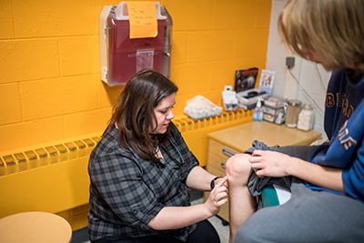 Kuzma checking the knee of a patient