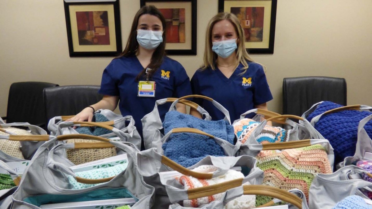 Two nursing students wearing masks with baby supplies 
