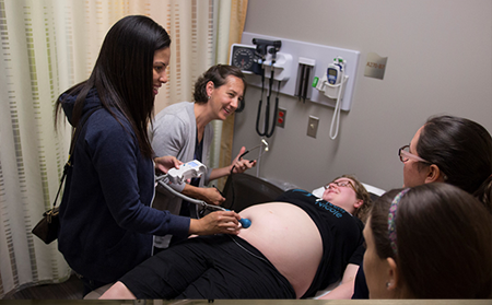 Graduate students working with a pregnant volunteer