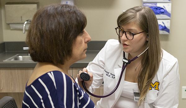 Student examines volunteer patient with stethoscope 