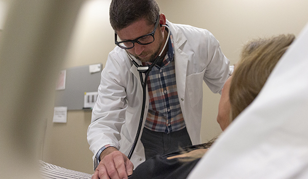 Nurse examines patient with stethoscope