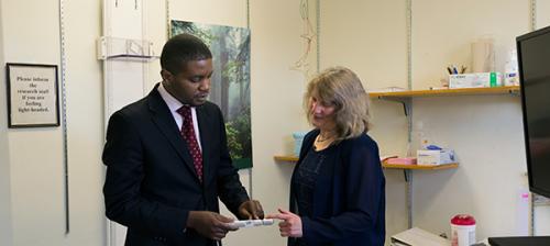 Alain Mukege and Janis Miller discuss a piece of research equipment