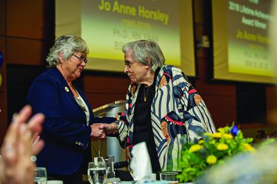 Joyce Crane (r) accepting Horsley's Lifetime Achievement Award from Linda Zoeller, president of UMSN's Alumni Society Board of Governors