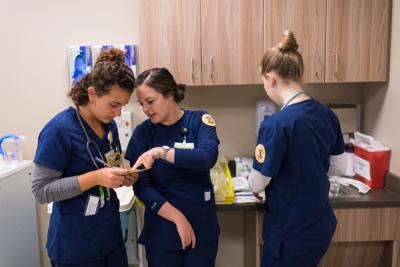 Katie DeGrace (left) consults her notes during an simulation learning exercise in UMSN's Clinical Learning Center