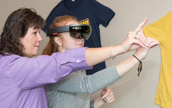 Aebersold teaches junior Lauren Skidmore how to use VR hand signals