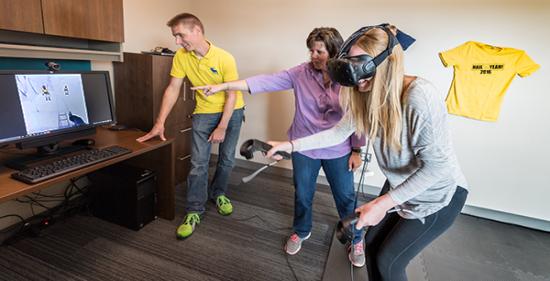 Junior Katie Burmester tries VR for the first time. Students play a fun mountain climbing game to familiarize themselves with the technology.