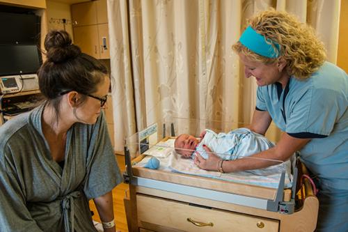 Proud mom Rachel Waddell looks on as Zielinski checks on baby Theo who was born the previous night.